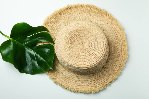 Солом'яний капелюх і пальмовий лист на білому тлі
 - Фото, зображення