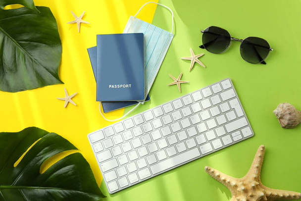 Toetsenbord, paspoorten met masker en vakantie accessoires op kleur achtergrond - Foto, afbeelding