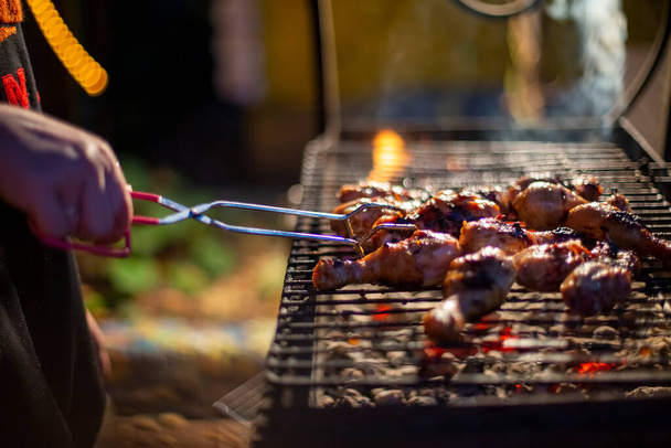 Chef cooking jerk barbecue BBQ chicken on the grill hand turning food. grilled meat - Photo, Image