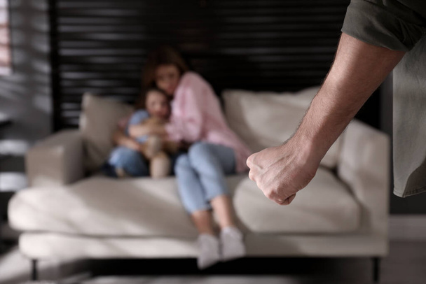 Απειλεί τη γυναίκα και την κόρη του στο σπίτι. Ενδοοικογενειακή βία - Φωτογραφία, εικόνα