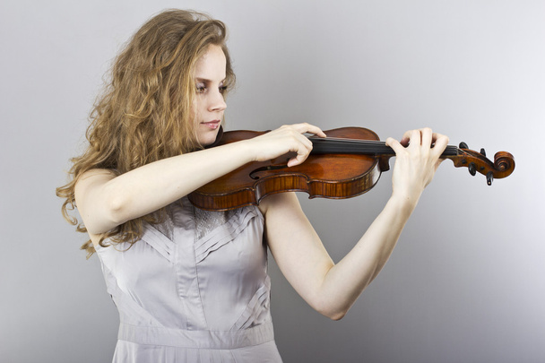 schöne junge blonde Frau im grauen Abendkleid mit roter Geige - Foto, Bild