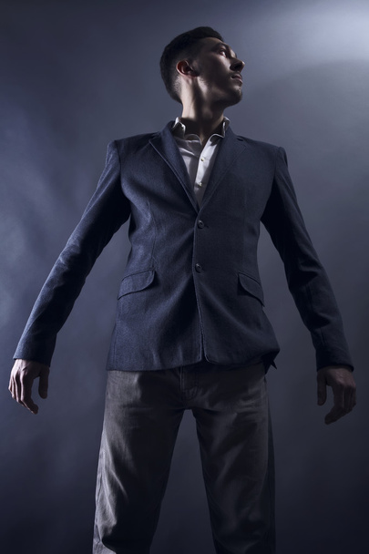 Young attractive man in suit on gray background - Fotó, kép