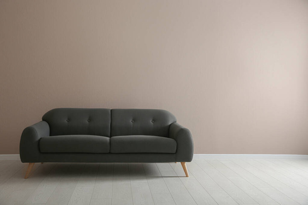 Comfortable grey sofa near beige wall indoors, space for text. Interior design - Fotografie, Obrázek