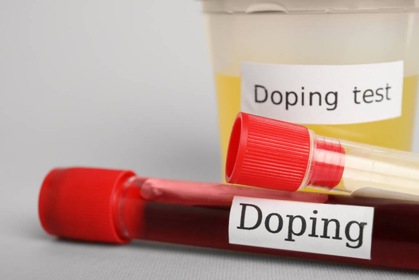 Closeup view of jar and test tubes with samples on light grey background. Doping control - Zdjęcie, obraz