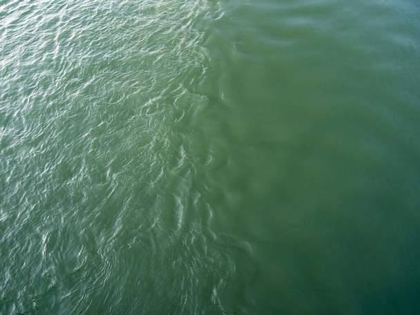 Абстрактний природний фон з водною текстурою. Вид зверху на смарагдову зелену воду. Поверхня річки покрита хвилями
. - Фото, зображення