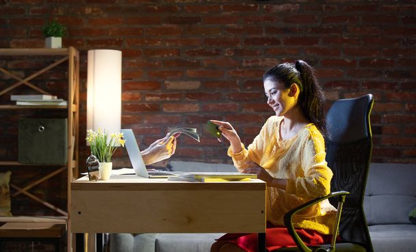 Young Caucasian woman using online banking through laptop. - 写真・画像
