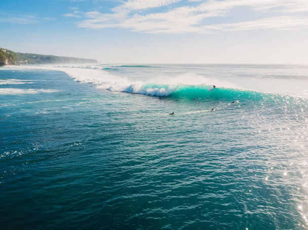 Blauwe golf met surfers in de oceaan, drone schot. Zicht vanuit de lucht op vatgolven - Foto, afbeelding