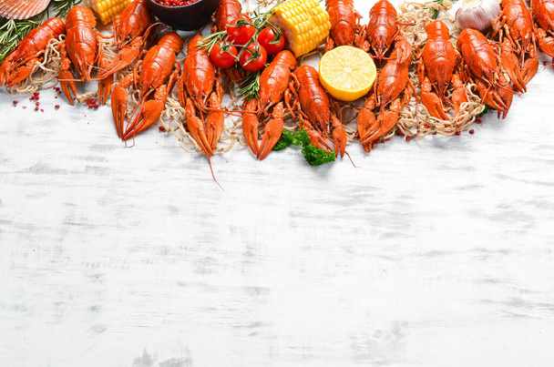Seafood banner. Red boiled crawfishes on table in rustic style, on a white wooden background. Top view. Flat lay. - Foto, Imagen
