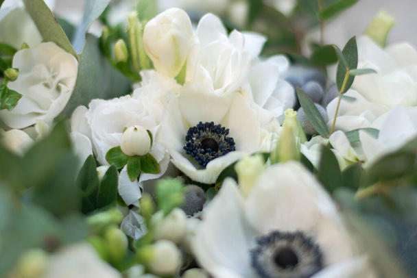 Clouse up bouquet of white flowers. White anemones. Wedding bouquet of white flowers and grennery. - Photo, Image