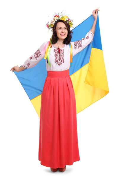 Happy woman in national clothes with flag of Ukraine on white background - Фото, изображение