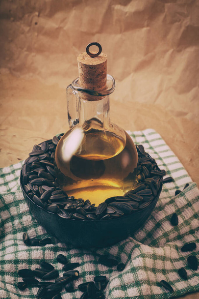 zonnebloemolie met een zak zaden en een houten lepel - Foto, afbeelding