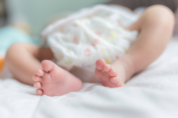 かわいい赤ちゃん嘘ベッドの上に新しい生まれ赤ちゃん足上のホワイトブランケット - 写真・画像