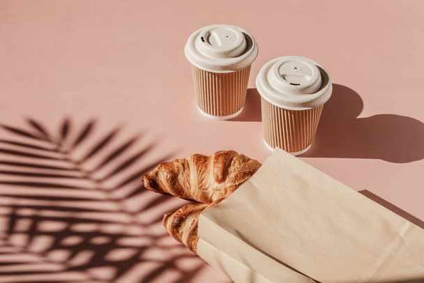 Caffè caldo in viaggio e croissant a colazione. Bicchieri da asporto monouso biodegradabili - Foto, immagini