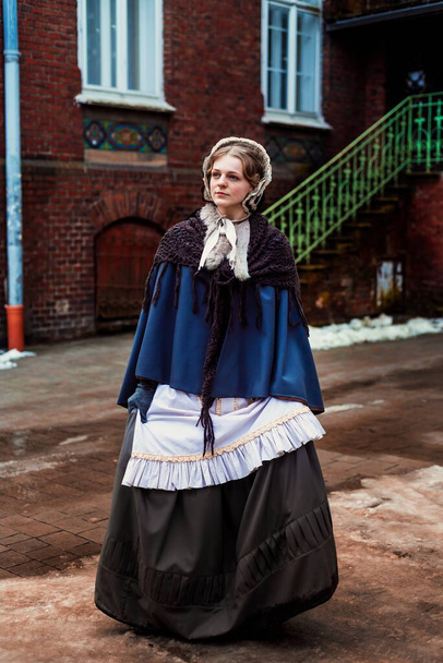Portrait en plein air d'une jeune femme victorienne marchant dans la vieille ville - Photo, image