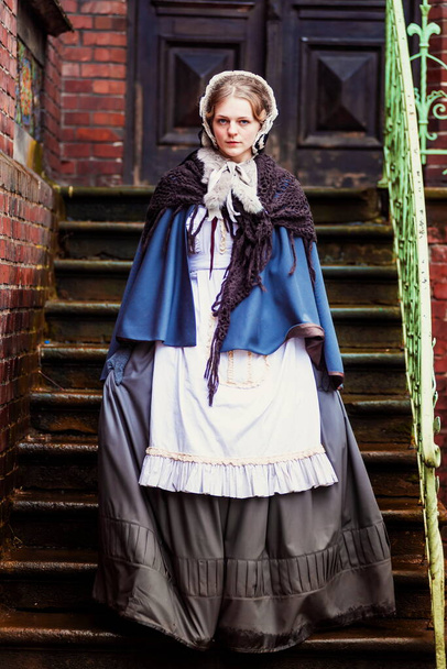 Draußen Porträt einer jungen viktorianischen Frau, die durch die Altstadt geht - Foto, Bild