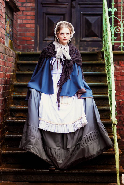 Draußen Porträt einer jungen viktorianischen Frau, die durch die Altstadt geht - Foto, Bild