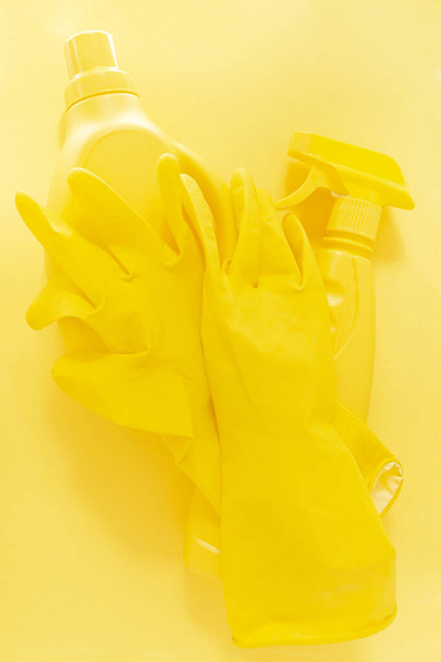 Κίτρινη μονόχρωμη επίπεδη διάταξη εργαλείων καθαρισμού. Πολύχρωμα λαστιχένια γάντια, σπρέι, φιάλη gel - Φωτογραφία, εικόνα