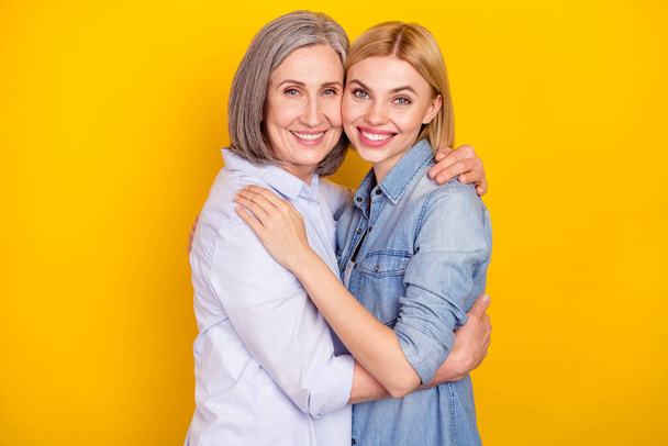Photo portrait of granddaughter embracing her smiling granny isolated bright yellow color background - Φωτογραφία, εικόνα