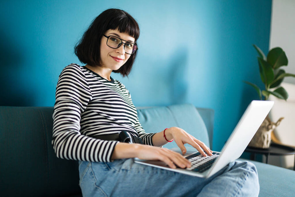 İletişim için dizüstü bilgisayar kullanan çekici bir kadın, karantinada görüntülü konuşma. Video görüşmesinde online toplantı. Karantina karantinasında evden çalışıyor. Sosyal Mesafe Öz İzolasyonu - Fotoğraf, Görsel