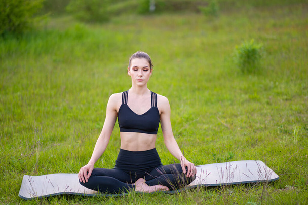 Mujer deportiva haciendo yoga y un estilo de vida saludable en la naturaleza. Deportes al aire libre - Foto, Imagen