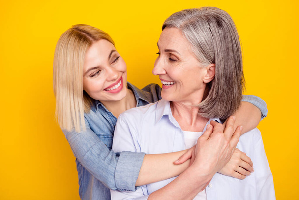 Photo portrait of mother and daughter cuddling together smiling isolated bright yellow color background - Valokuva, kuva