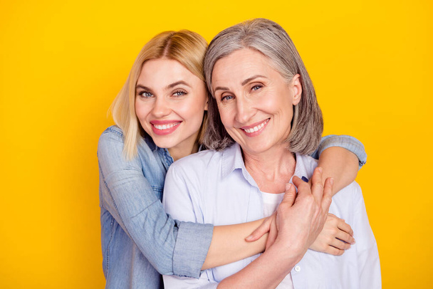 Photo portrait of daughter embracing her mum smiling dreamy isolated bright yellow color background copyspace - Фото, зображення