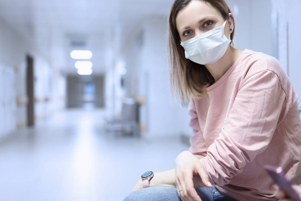 Ritratto di donna in maschera protettiva medica nel corridoio dell'ospedale - Foto, immagini