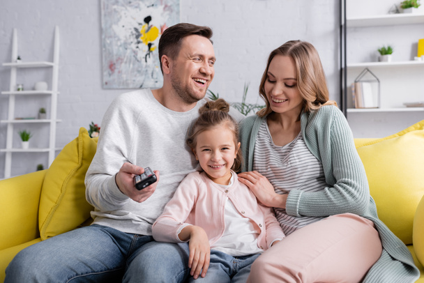 Cheerful family watching movie on couch  - Fotografie, Obrázek