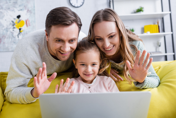 Familia alegre tener chat de vídeo en el ordenador portátil en la sala de estar  - Foto, Imagen