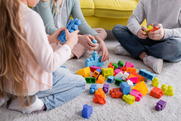 Cropped view of family near colorful building blocks on floor  - Photo, Image