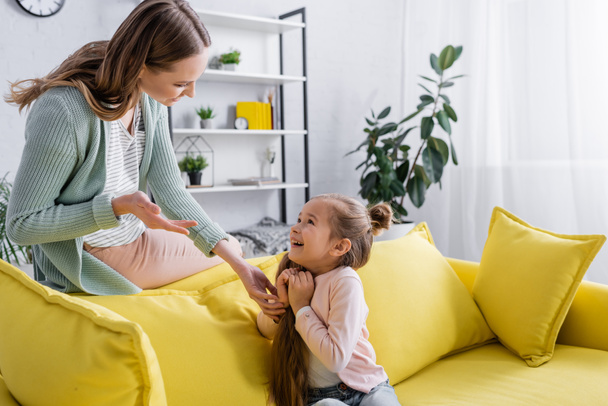 Mother talking with kid on couch at home  - Photo, Image