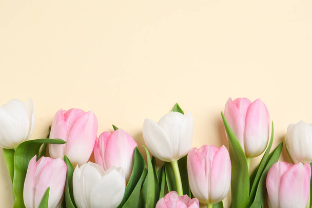 Beautiful pink spring tulips on beige background, flat lay. Space for text - Zdjęcie, obraz