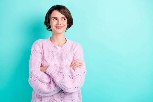 Photo of adorable sweet young lady dressed purple pullover looking empty space arms folded isolated teal color background - Φωτογραφία, εικόνα