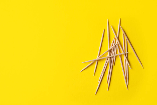 Wooden toothpicks on yellow background, flat lay. Space for text - Foto, afbeelding