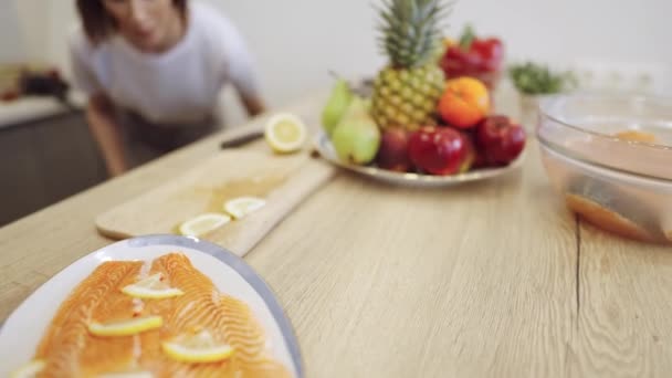 Tál gyümölcsökkel, zöldségekkel és lazacokkal az asztalon - Felvétel, videó