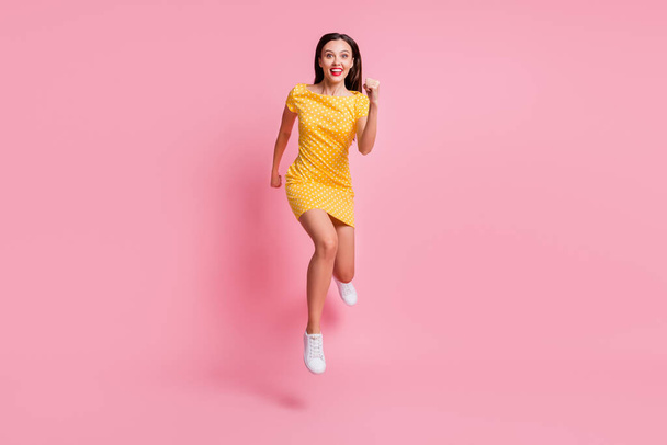 Foto de tamaño completo de atractiva mujer loca joven salto aire correr venta rápida aislado en pastel brillo color rosa fondo - Foto, imagen