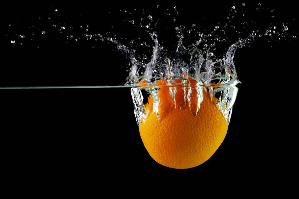 tangerine in water on a black background, place under the text - Foto, Imagen