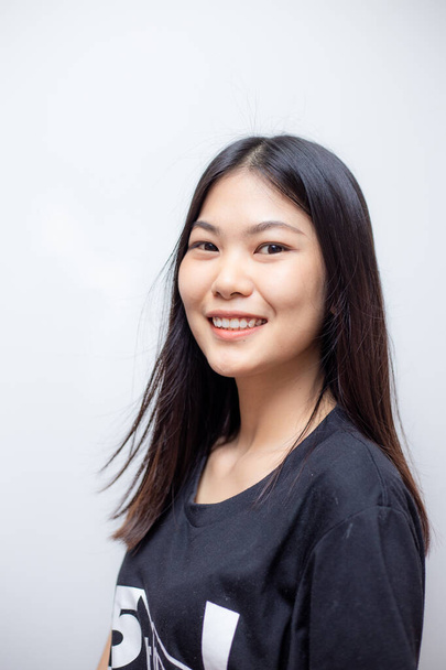 Joven hermosa mujer asiática posando con camiseta negra sobre fondo blanco - Foto, imagen