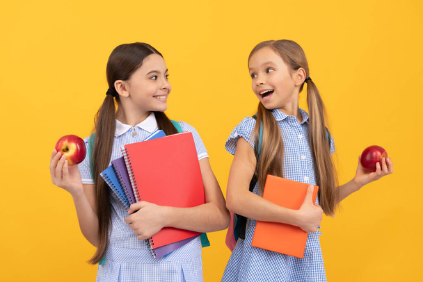 Get healthy back to school start. Happy kids hold books and apples. Healthy eating. School nutrition. Food education. Nutritious diet. Make fruit compulsory. - 写真・画像