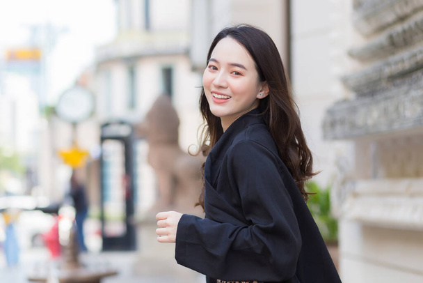 Uma imagem de uma bela mulher bonita asiática de cabelos compridos em um manto preto sorrindo alegremente - Foto, Imagem
