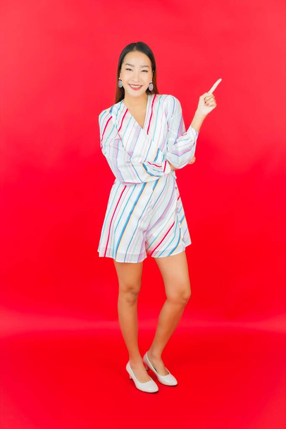 Portrait beautiful young asian woman smile with many action on red background - Foto, imagen