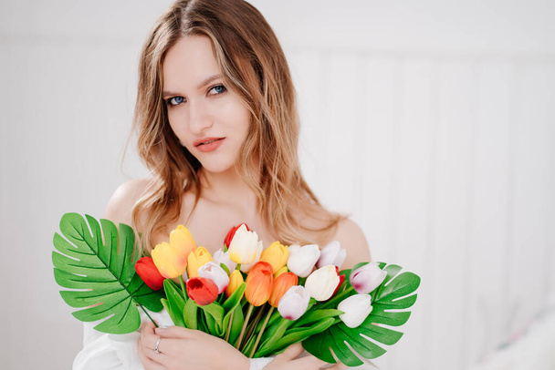 beautiful young woman with a bouquet of colorful tulips - Fotoğraf, Görsel
