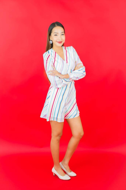 Portrait beautiful young asian woman smile with many action on red background - Foto, Imagen