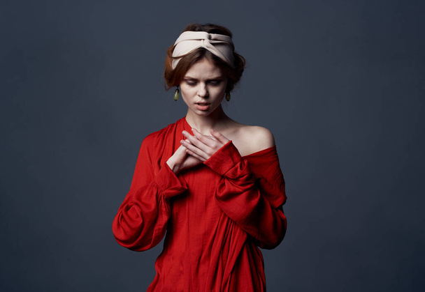 mooie vrouw met een tulband op haar hoofd aantrekkelijk look rood jurk close-up - Foto, afbeelding