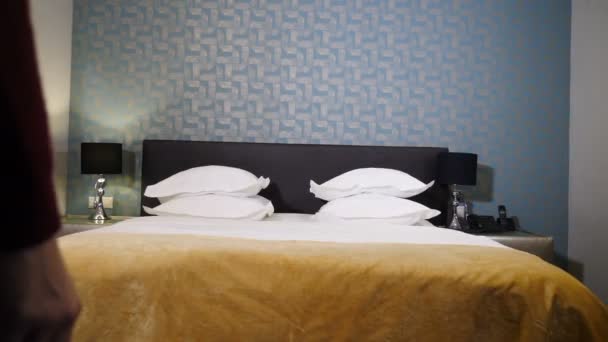 Glückliche Touristin im Urlaub springt im Hotelzimmer aufs Bett. Weibliche Gäste springen im Laufschritt in ein bequemes King-Size-Bett im luxuriösen Hotelzimmer und entspannen dann. Urlaubskonzept. 4 k video - Filmmaterial, Video