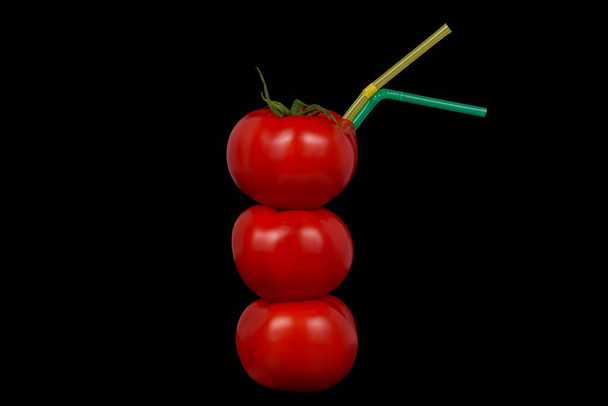 Een stapel van drie tomaten met cocktailtubes.  - Foto, afbeelding
