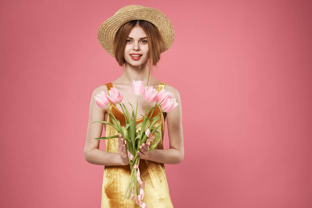 Beautiful woman golden dress and bouquet of flowers holiday elegant style pink background - Foto, Imagem