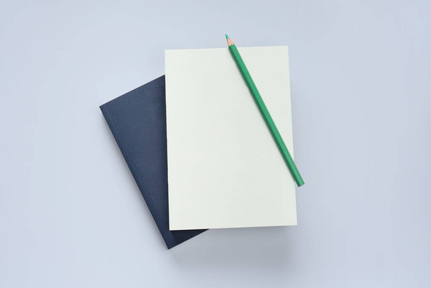 plat legboek en briefpapier op blauwe pastelvloer - Foto, afbeelding