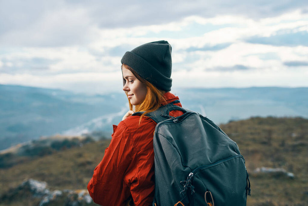 energiczna kobieta w ciepłych ubraniach z plecakiem turystyka turystyczna góry widok z tyłu - Zdjęcie, obraz
