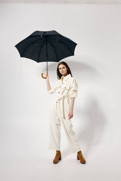 pretty woman on modern fashionable suit brown boots umbrella over head - Photo, Image